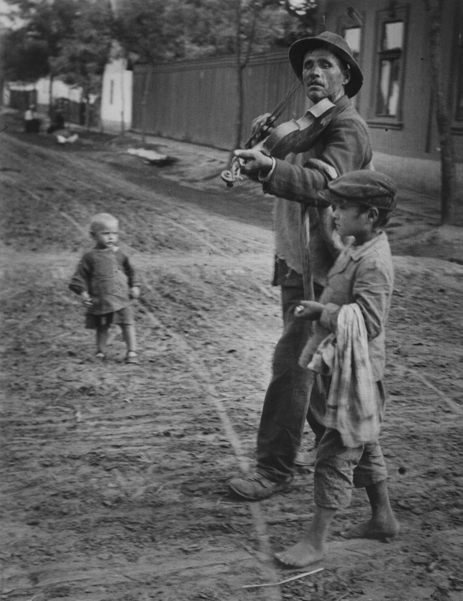 ANDRÉ KERTÉSZ, Wandering Violinist, Abony, Hungary,: ANDRÉ KERTÉSZ, WANDERING VIOLINIST, ABONY, HUNGARY, JULY 21,1921 gelatin silver print, printed c. 1960s, 14 x 11 in. (sheet), 20 x 16 (matted); unsigned, stamped verso; Condition: Excellent. EG# AKE