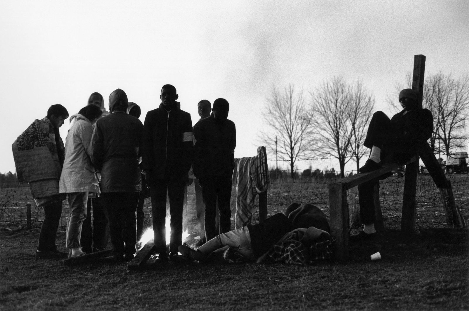 CHARLES MOORE Hard-core marchers huddle, 1965: CHARLES MOORE (1931-2010), HARD-CORE MARCHERS HUDDLE BY AN EARLY MORNING FIRE. SOME THREE HUNDRED WENT THE ENTIRE DISTANCE CAMPING BY THE ROAD. OTHER MARCHERS RETURNED TO THEIR HOMES AT NIGHT OR SLEPT