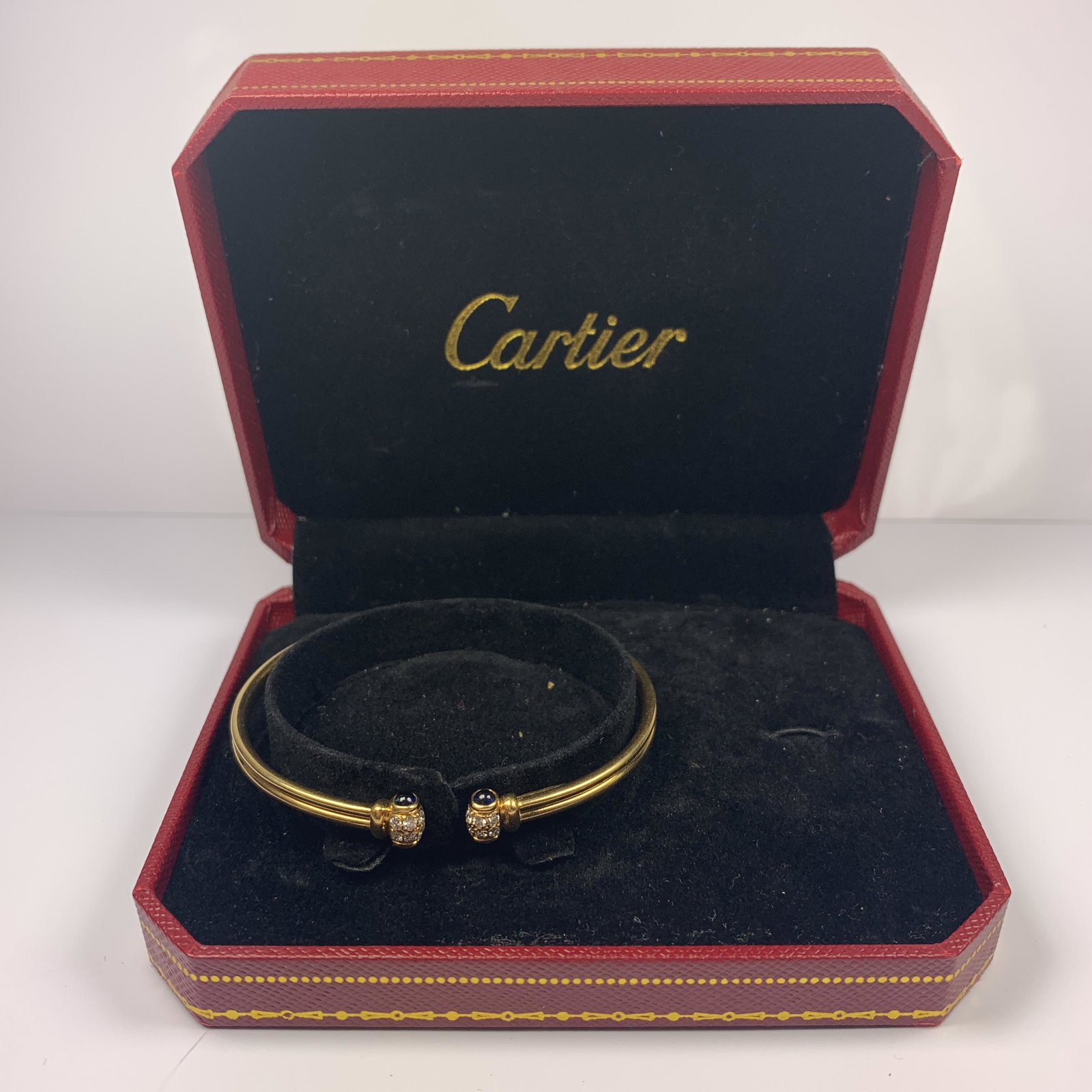Vintage Cartier 18k Gold Diamond Sapphire Cuff Bracelet: The piece is exquisitely crafted in solid 18k yellow gold with a smooth high polished finish adorned with 12 (1.1) clean sparkling diamonds and accented with 4 cabochon blue sapphires. Stamped CARTIER