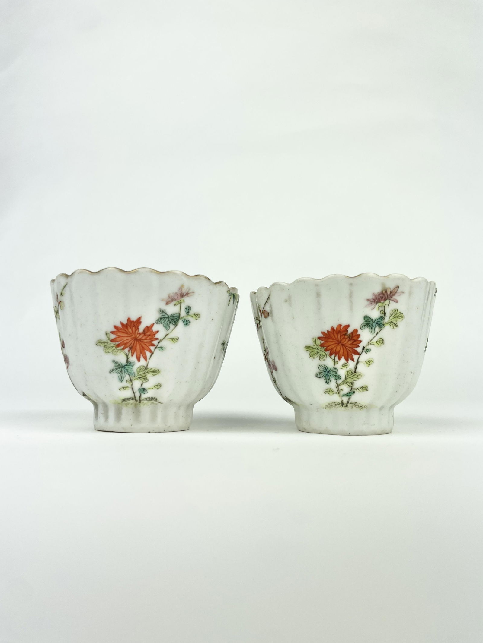 A Chinese Pair of Famille Rose Fluted Porcelain Tea: A Chinese Pair of Famille Rose Fluted Porcelain Tea Cups well painted with red chrysanthemum and bamboo. Dating 19th Century, Qing Dynasty. Approximate DImensions: 1.75 inches ( height) x 2.25 inches