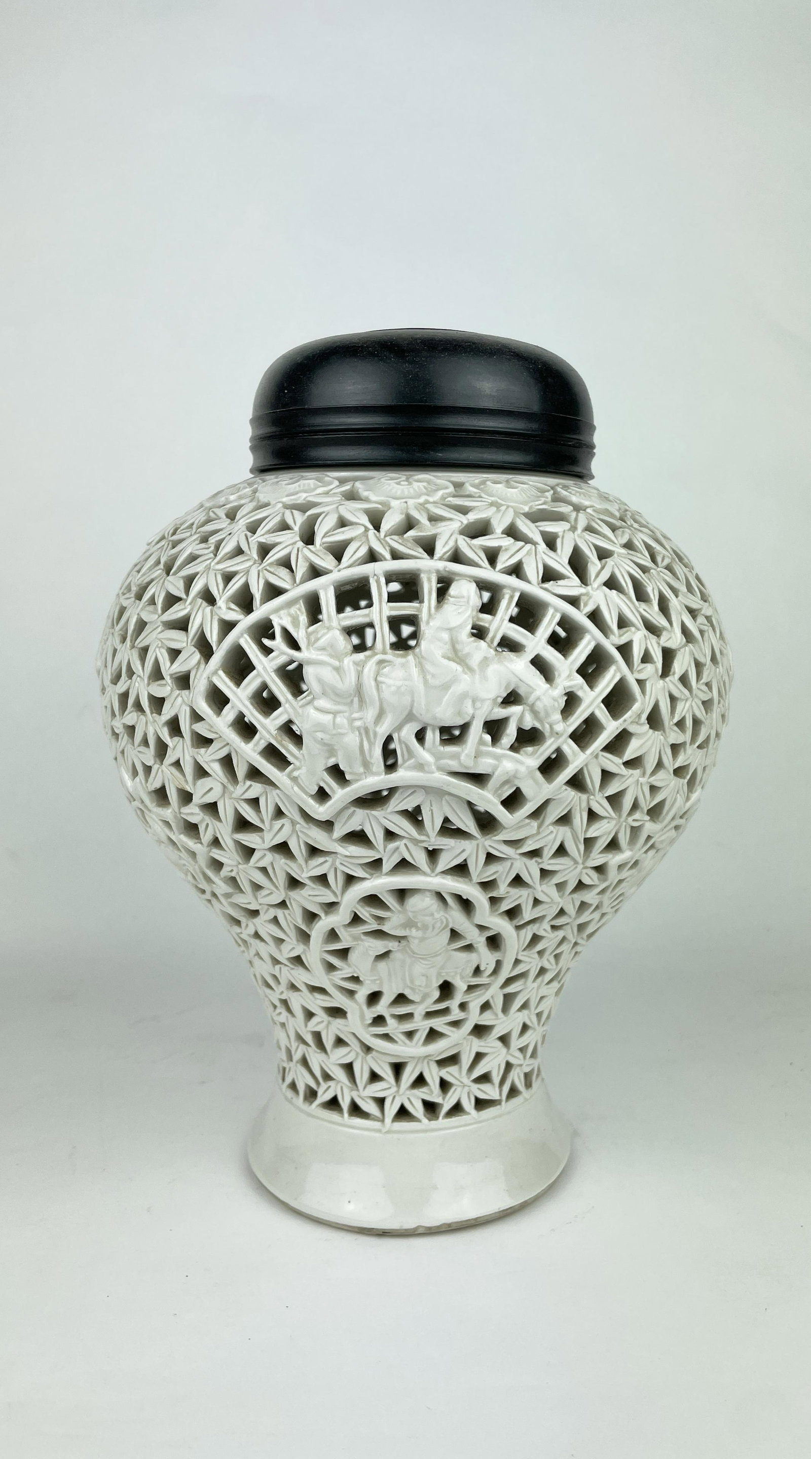 A Chinese Dehua Porcelain Ginger Jar: A Chinese Hollow Carved Dehua Porcelain Ginger Jar with wooden base, the base marked "CHINA" and features an old sale sticker, Republic Period. Approximate Dimensions: 10.5 inches (height) x 3.5 inche