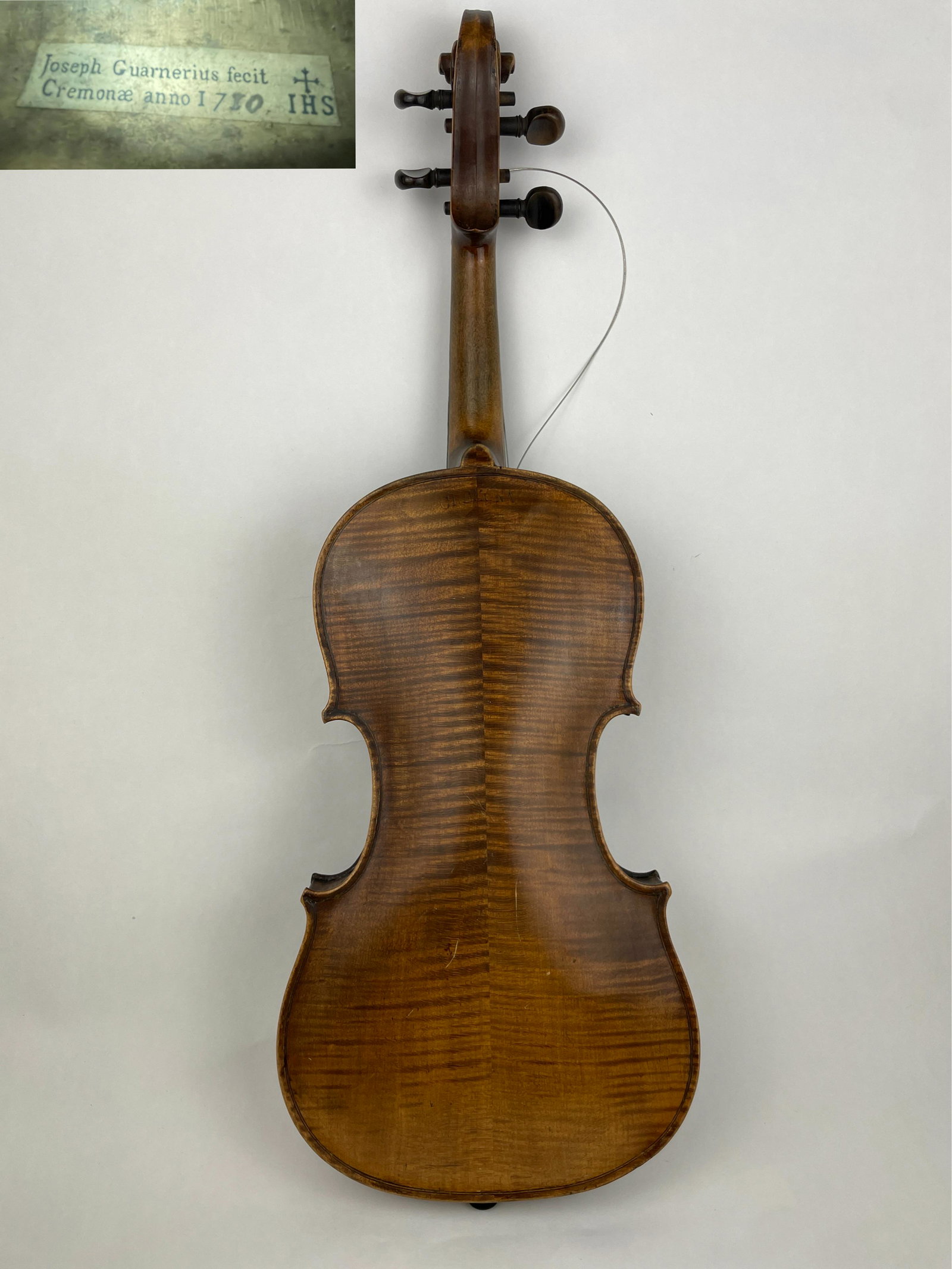 A Violin By Joseph Guarnerius Branded Cremona: A Violin By Joseph Guarnerius Branded Cremona accompanied by a bridge stamped BAUSCH. The instrument is branded : CREMONA below on the button and features a label on interior that reads : Joseph Guarn