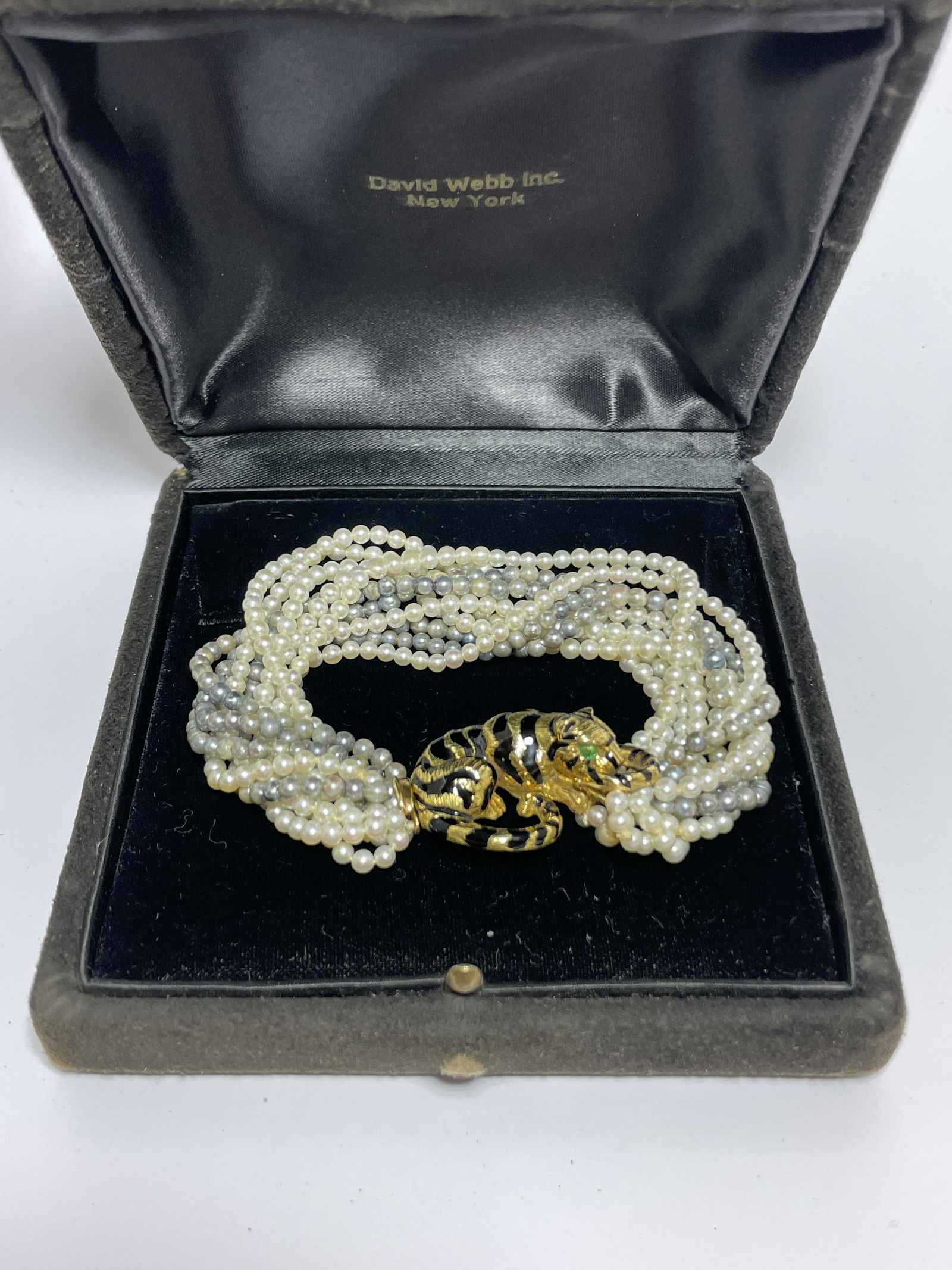 A Vintage David Webb 18k Gold Pearl and Enamel Bracelet: A Vintage David Webb 18k Gold Pearl and Enamel Bracelet Circa 1980s, a multi-strand of Pearls accenting a quality 18k Gold & Enameled recumbent Tiger, the back of the tiger stamped "WEBB 18K". Jewelr