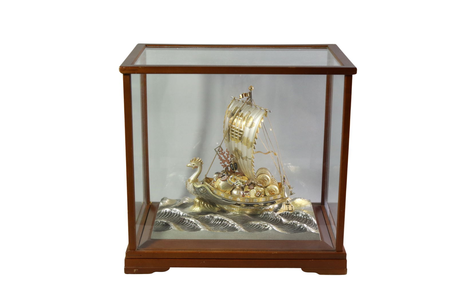 TAKEHIKO SEKI JAPANESE SILVER TREASURE SHIP: TAKEHIKO SEKI JAPANESE SILVER TREASURE SHIP Japanese silver treasure ship by Takehiko Seki, crafted with detailed rigging, sail, and dragon-head prow. The ship is filled with symbolic treasures, repre