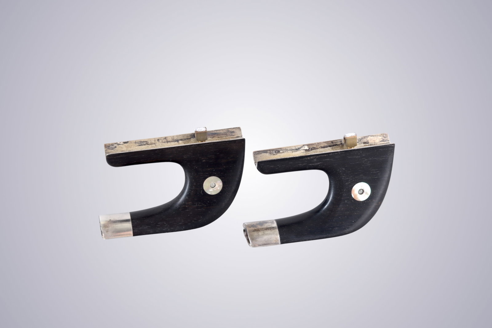 TWO GERMAN STYLE SILVER MOUNTED BASS BOW FROGS WITH STANHOPE LENS: TWO GERMAN STYLE SILVER MOUNTED BASS BOW FROGS WITH STANHOPE LENS A pair of German-style ebony bass bow frogs mounted in silver and fitted with pearl eyes. Concealed within the pearl eyes are