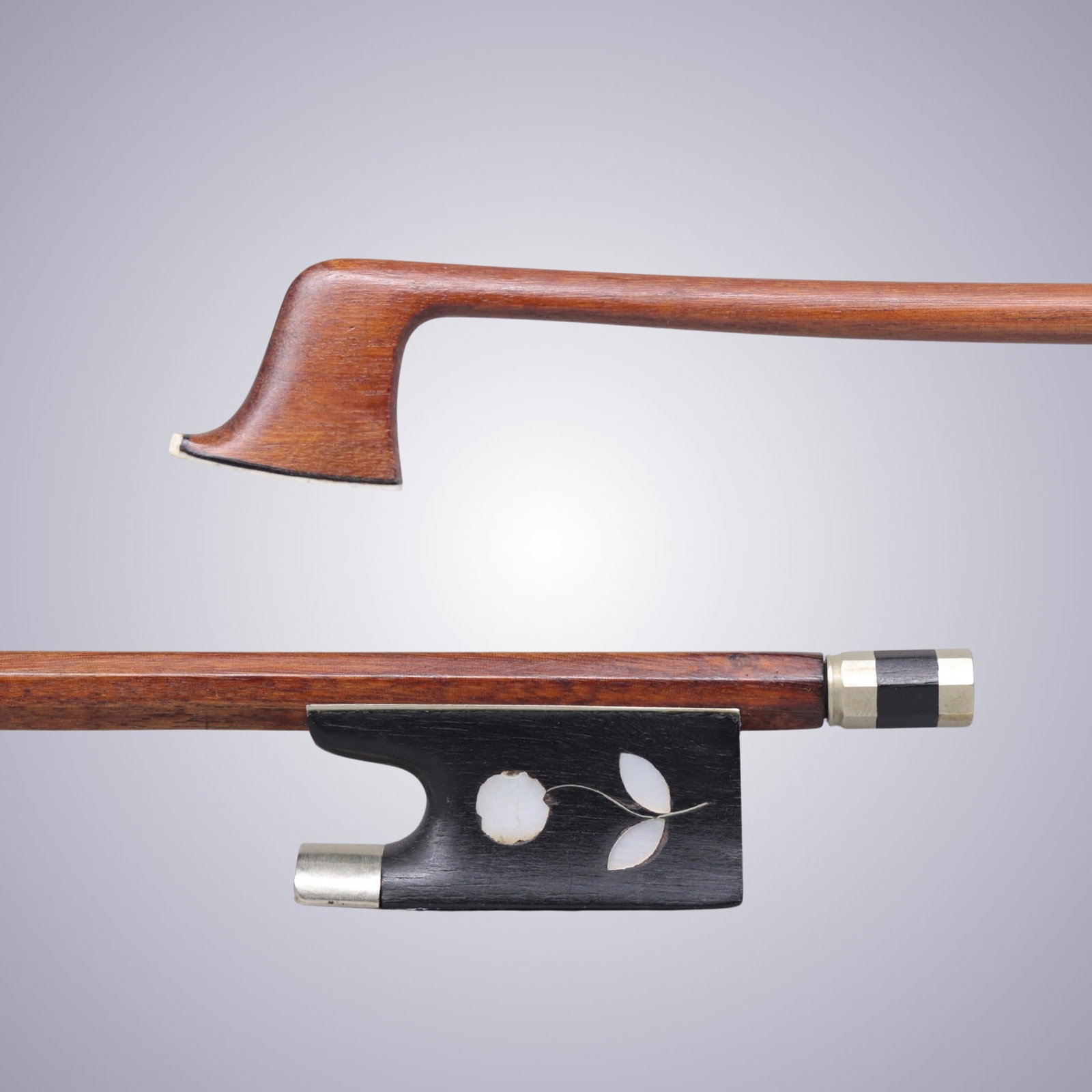 A VIOLIN BOW ATTRIBUTED TO KNOPF WORKSHOP: A VIOLIN BOW ATTRIBUTED TO KNOPF WORKSHOP Of Strong, Round Pernambuco Stick, Ebony & Nickel mounted - with a mother-of-pearl Flower inlay design on Ebony Frog. Stamped on understick: GERMANY