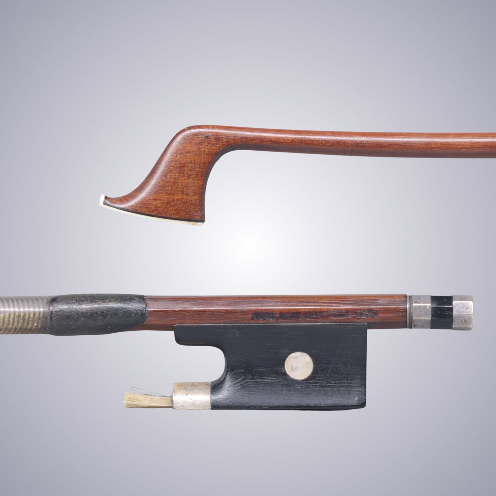 AN INTERESTING SILVER MOUNTED VIOLIN BOW ATTRIBUTED TO CARL FISCHER NY: AN INTERESTING SILVER MOUNTED VIOLIN BOW ATTRIBUTED TO CARL FISCHER NY Of Round Pernambuco Stick, Ebony & Silver mounted. Stamped on stick above frog: CARL FISCHER NY Faintly Stamped on frog -