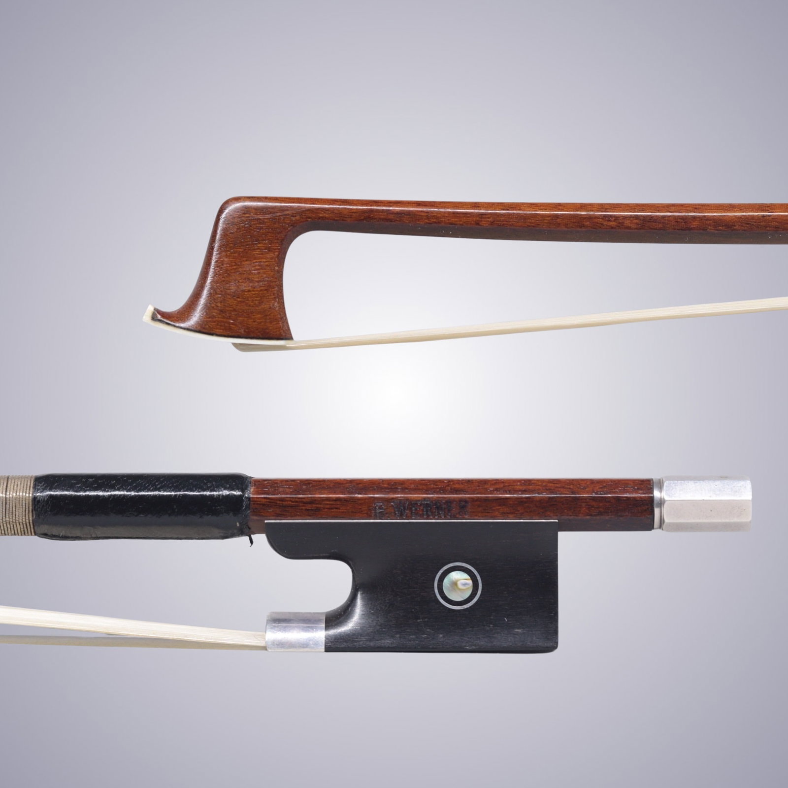 A SILVER MOUNTED VIOLIN BOW STAMPED E. WERNER: A SILVER MOUNTED VIOLIN BOW STAMPED E. WERNER Of Octagonal Pernambuco Stick, Ebony & Silver mounted. Stamped on stick above frog: E. WERNER Approximate Dimensions: 74.7 cm (Total Length - Head to Adju