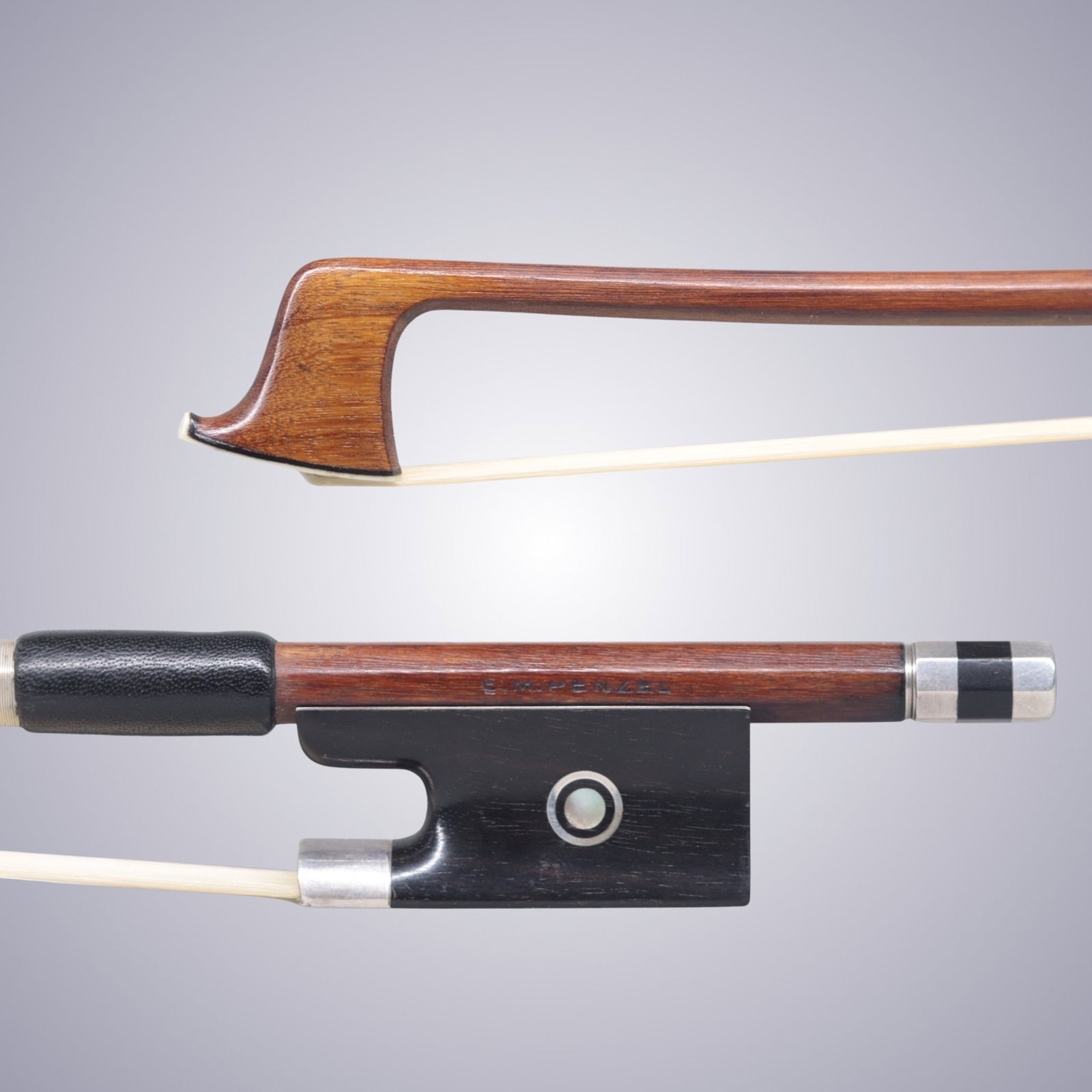 A SILVER MOUNTED VIOLIN BOW STAMPED E.M. PENZEL: A SILVER MOUNTED VIOLIN BOW STAMPED E.M. PENZEL Of Octagonal Pernambuco Stick, Ebony & Silver mounted. Stamped on stick above frog: E.M. PENZEL Approximate Dimensions: 74.5 cm (Total Length - Head to