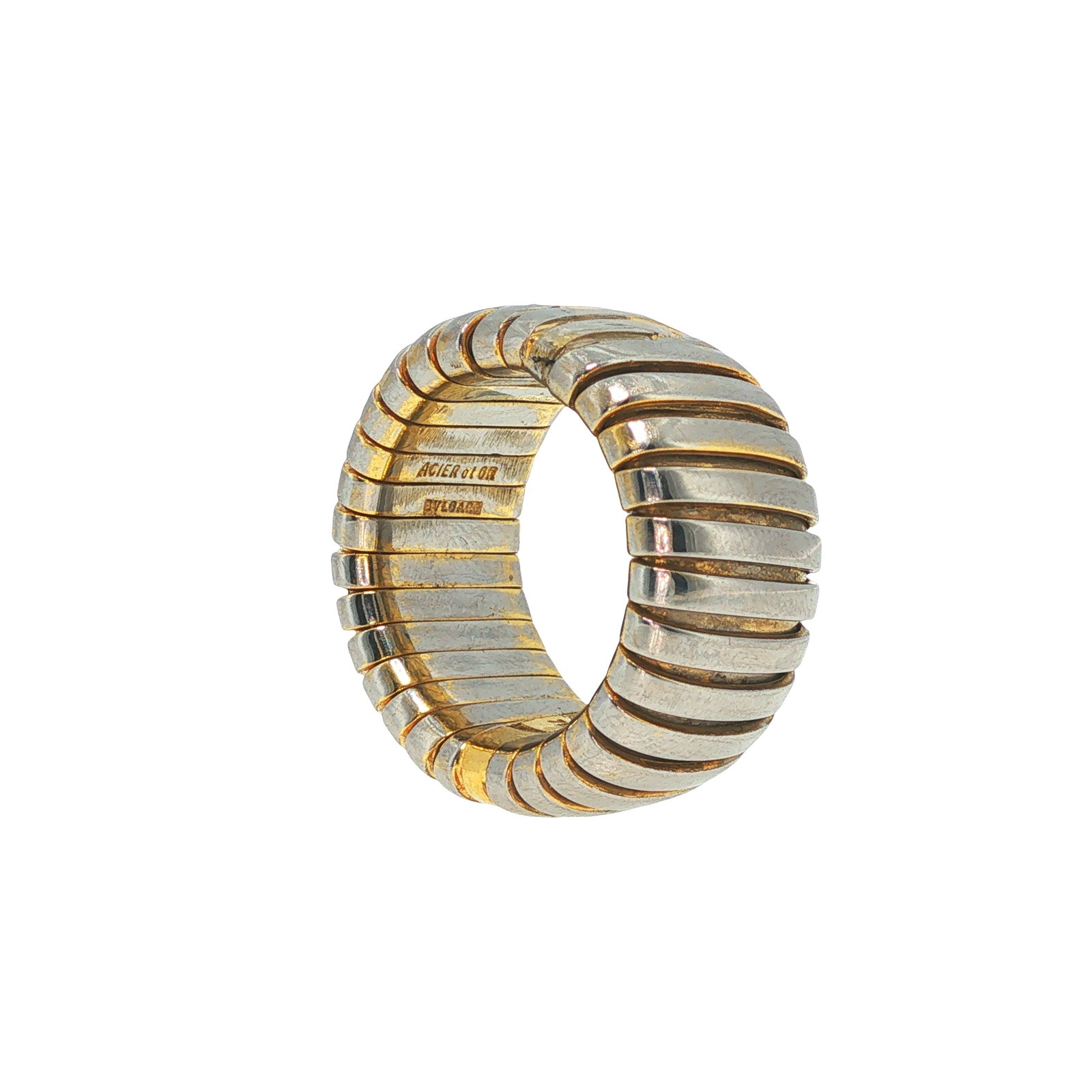 BULGARI 18K GOLD AND STEEL TUBOGAS RING: BULGARI 18K GOLD AND STEEL TUBOGAS RING An iconic Bulgari Tubogas ring crafted in 18 karat yellow gold and stainless steel. The ring is designed as a flexible wrap-style band composed of alternating p