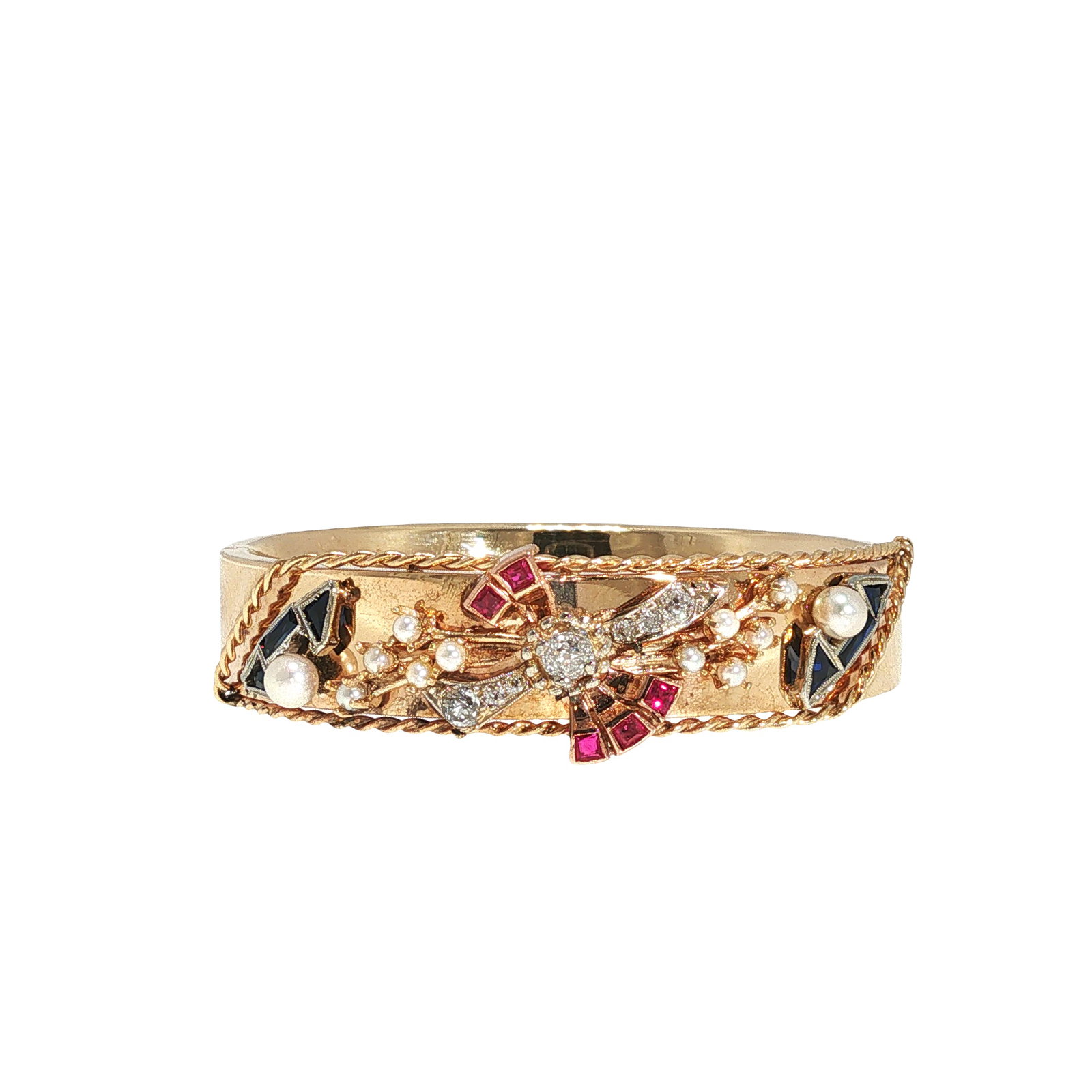 14K GOLD DIAMOND SAPPHIRE RUBY AND PEARL CUFF BRACELET: 14K GOLD DIAMOND, SAPPHIRE, RUBY AND PEARL CUFF BRACELET A 14K gold hinged cuff bracelet centering an Art Deco style floral motif accented by old-cut diamonds, calibre-cut rubies, sapphires, and seed