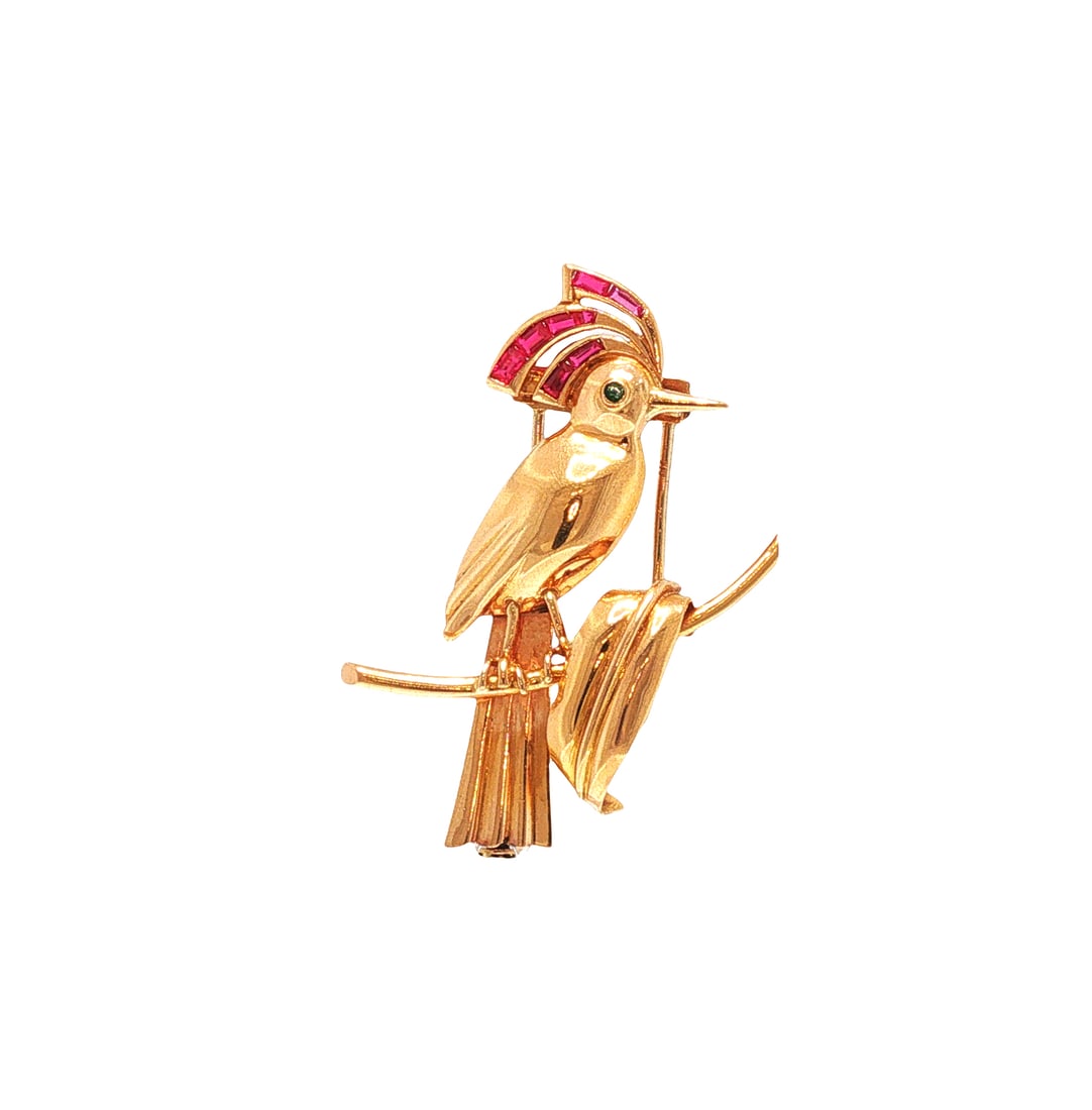 RETRO 14K GOLD RUBY & EMERALD BIRD BROOCH: RETRO 14K GOLD RUBY & EMERALD BIRD BROOCH A Retro 14K yellow gold brooch modeled as a stylized crested bird perched upon a branch, the sweeping crest channel-set with calibre-cut rubies and the eye ac