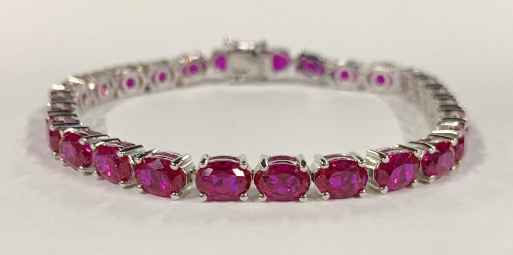 Sterling Bracelet with Pink Stones: Sterling Bracelet with Pink Sapphire-like Stones. Apx. 8. Stone are individually Set - Double Lock. Photo's are considered part of the description and condition.