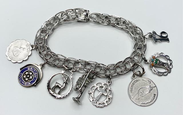 Sterling Charm Bracelet w/8 Charms: Sterling charm bracelet with 8 charms. *To my Bridesmaid *British Columbia *Reindeer *Trumpet *Cross *Drumheller Prehistoric Parks *Stocking *Sweet 16. Beautifully designed bracelet with box latch cla