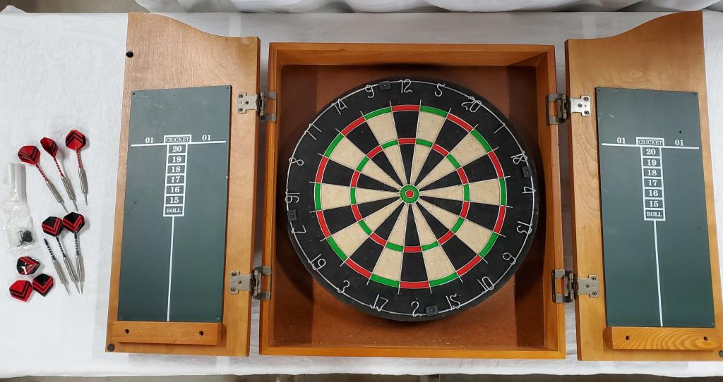 Heavy Duty Dart Board in Wood Cabinet: Heavy Duty Dart Board in Wood Cabinet. Bristle Board Apx. 18" Diameter. Cabinet Closed Apx. 25" H x 20 1/4" W. Open Apx. 25" H x 41" W. Includes 6 darts and Chalk. Photos are considered part of the de