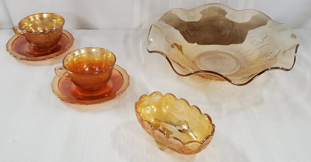 6 Pieces of Amber Depression: 6 Pieces of Amber Depression Glass. *Footed Candy/Nut Dish Apx. 2" H x 5 1/4" W. *Iris & Herrin bone Marigold Glass Bowl Apx. 11 1/2". *Set of 2 Bouquet and Lattice Iridescent Tea Cup and Saucers. Pho