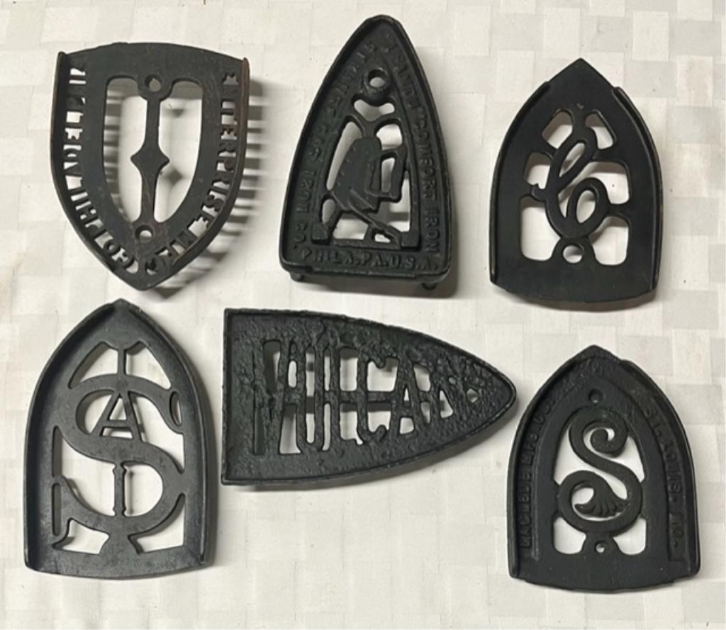 6 Vintage Cast Iron Trivets: 6 Vintage cast iron trivets. Assorted sizes, designs and makers. Photos are considered part of the description and condition.
