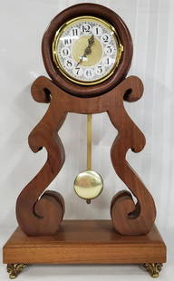 Banjo Style Mantle Clock: Banjo Style Mantle Clock. Wood Case. Brass Feet. Battery Operated. Works.Apx. 17 1/2" H x 10 1/2" W x 5" D. Photo's are considered part of the description and condition. O