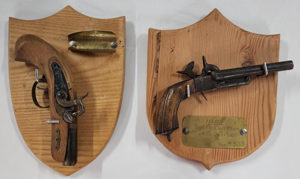 Wall Mounted Smith & Wesson and Derringer: Wall Mounted Smith & Wesson and Derringer. *Brass Plaque reads: 1882 Smith and Wesson 45 Caliber - Serial #533. *Brass Plaque Reads: 1825 Philadelphia Derringer. 45 Caliber Ball - Serial #378545. Both