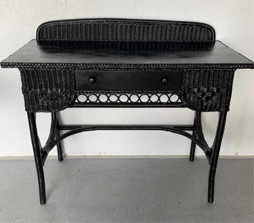 Black Wicker Desk with Center Drawer: Black Wicker Desk with Center Drawer and Back Splash. Some Paint Chips. Nice Condition. Apx. 43" W x 20" D x 33" H. Photo's are considered part of the description and condition. 200
