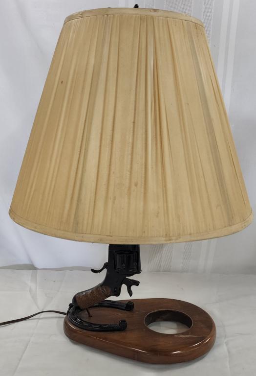 Italian Military Revolver Gun Lamp: Italian Military Revolver Gun Lamp. Revolver is sitting on a horseshoe and wood base made into a lamp. Apx. 24" H. Photos are considered part of the description and condition.