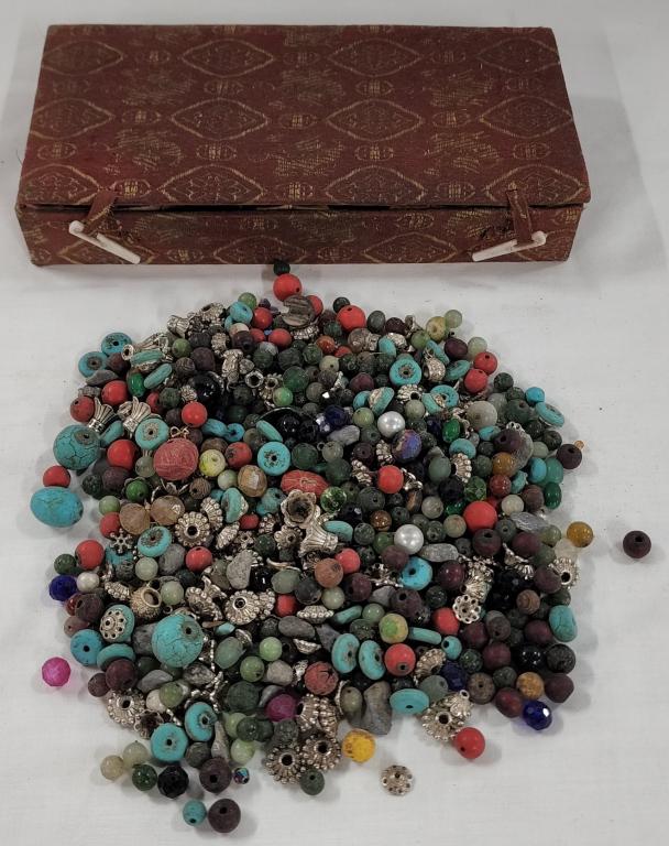 Box of Assorted Asian Style Beads: Box of Assorted Asian Style Beads. Some Glass, some Metal, some Stone? Fabric Covered Asian Style Box needs to be cleaned. Box Size Apx. 1 1/4" H x 7 1/2" L x 3 1/2" W. Photo's are considered part of