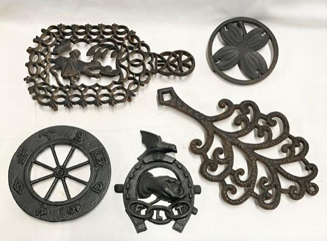 5 Wrought Iron Trivets: 5 wrought iron trivets. * Ornamental/ Wilton - approx. 12"D. * Red Riding Hood - approx. 11"H. * Dogwood - Monticello - H. Burnes - approx. 5"D.