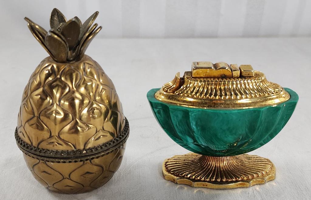 2 Art Deco Table Lighters: 2 art deco table lights. * ASR gold tone and green - approx. 3"H. * Evans pineapple gold tone - approx. 3.5"H. Unknown working condition. Have not been tested. Photos are considered part of the descri