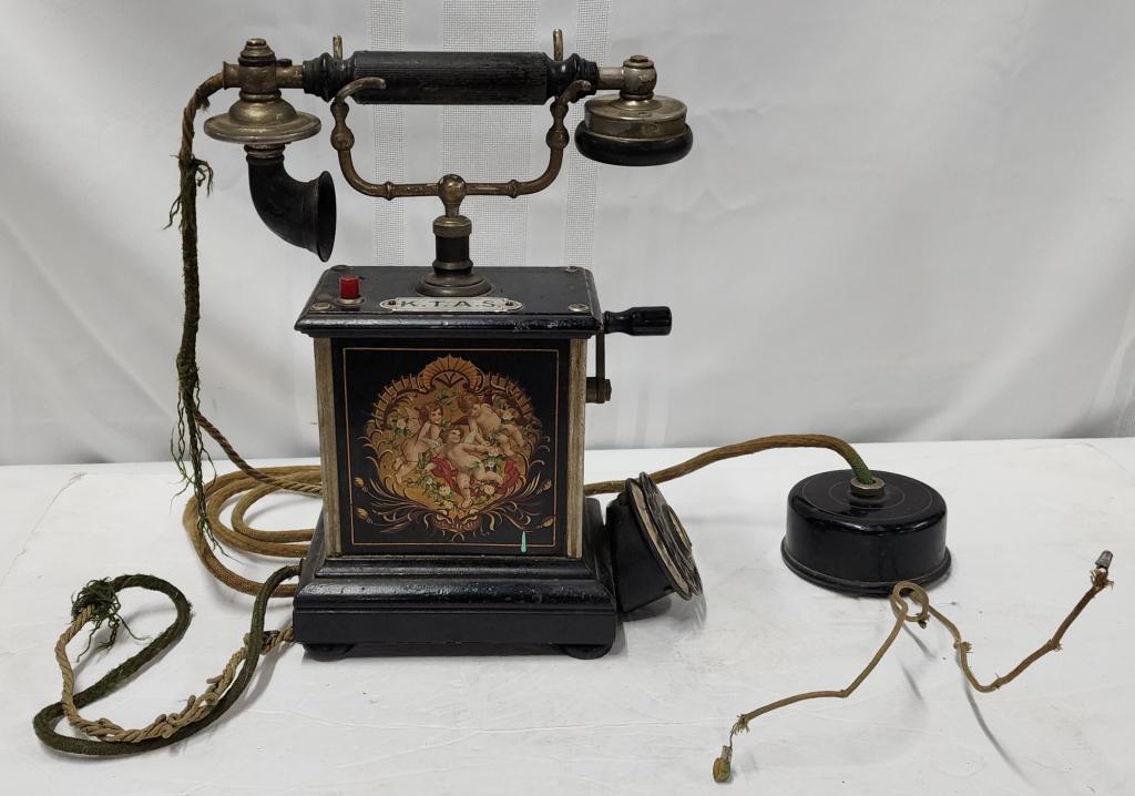K.T.A.S. Danish Hand Crank Telephone: K.T.A.S. Danish Hand Crank Telephone.Hand Painted Angels on metal case.Approx.. 13"H.Working Condition Unknown.Telephone is aged.Photos are considered part of the condition and description.801-590.