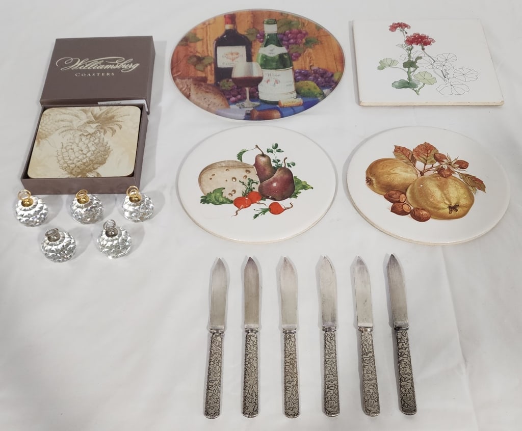 Assorted Kitchen Items: Assorted Kitchen Items. *6 Silverplate Knives. Approx. 5.75"L. *5 Faceted Crystal Card Holders/Paperweight (some small nicks). *4 Trivets-one has cracks & chips. *4 Williamsburg Pineapple Coasters in