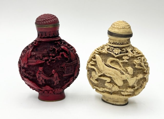 Pair of Carved Asian Snuff Bottles: Pair of Beautifully Carved Asian Snuff Bottles. One Red, One White. Approx. 2.25"H. White Bottle has spoon attached to lid, but missing part of stopper. Red Bottle is missing spoon and lid does not st