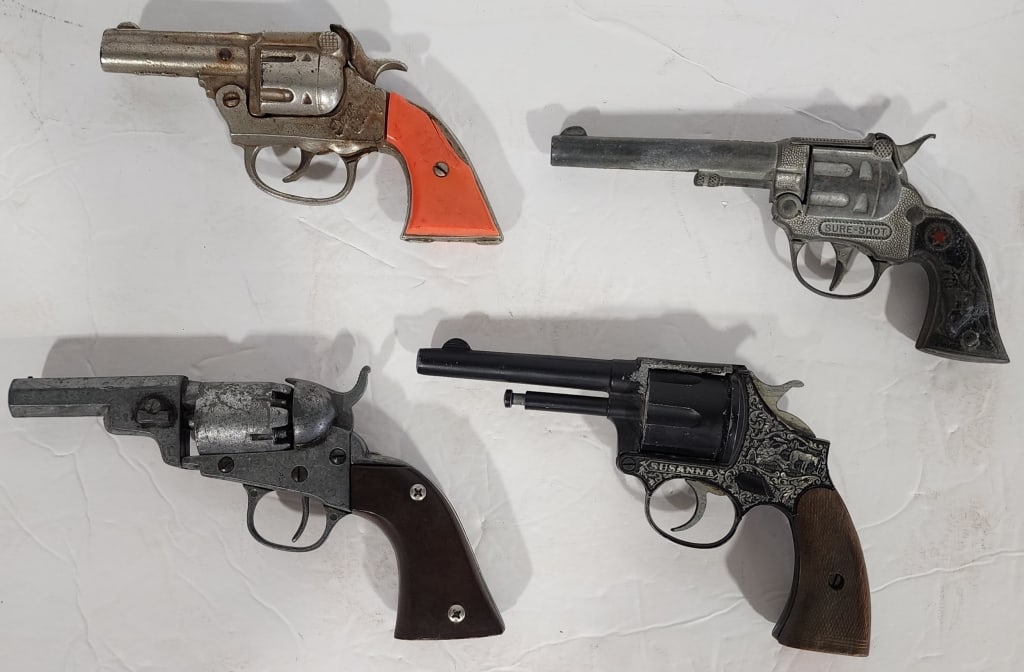 Collection of 4 Assorted Vintage Cap Guns: Collection of 4 Assorted Vintage Cap Guns. *1950's Sure Shot Cap Gun. In working condition. *Gene Autry Cap Gun. Working Condition Unknown. Has not been tested. *Susanna. Made in Italy by Edison. gioc