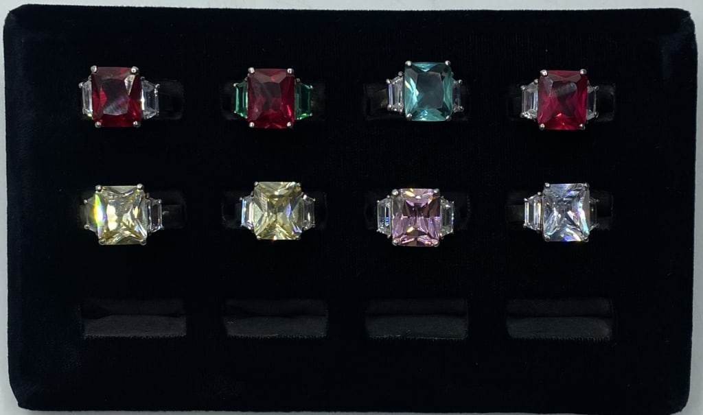 Assortment of 8 Sterling Rings: Assortment of 8 Sterling Rings. Sterling Silver with 3 Faceted Stone Setting. Marked 925. Colors and Sizes vary. Photos are considered part of the description and condition.