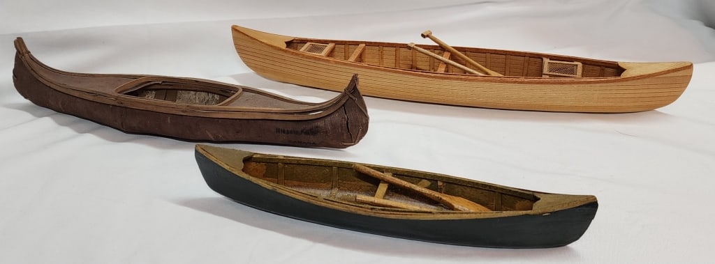 3 Small Wooden Collectible Boats/Canoes: 3 Wooden boats/canoes. 2 Have oars. One boat has a crack in the side. Approx. 16"L, 9.5"L, & 12"L. Photos are considered part of the description and condition.