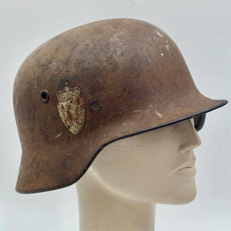 Norwegian M40 Double Decal Helmet: Norwegian M40 double decal helmet. No strap or internal liner. Helmet is in aged condition. Approximately 6"h x 11"l x 9"w. Photos are considered part of the condition and description. 610-17