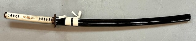 40" Japanese Samurai Katana Sword: 40" Japanese samurai katana sword. Scabbard made of wood. Brass accents. Blade approximately 30" long. Engraving on blade. Photos are considered part of the condition and description. 404-34
