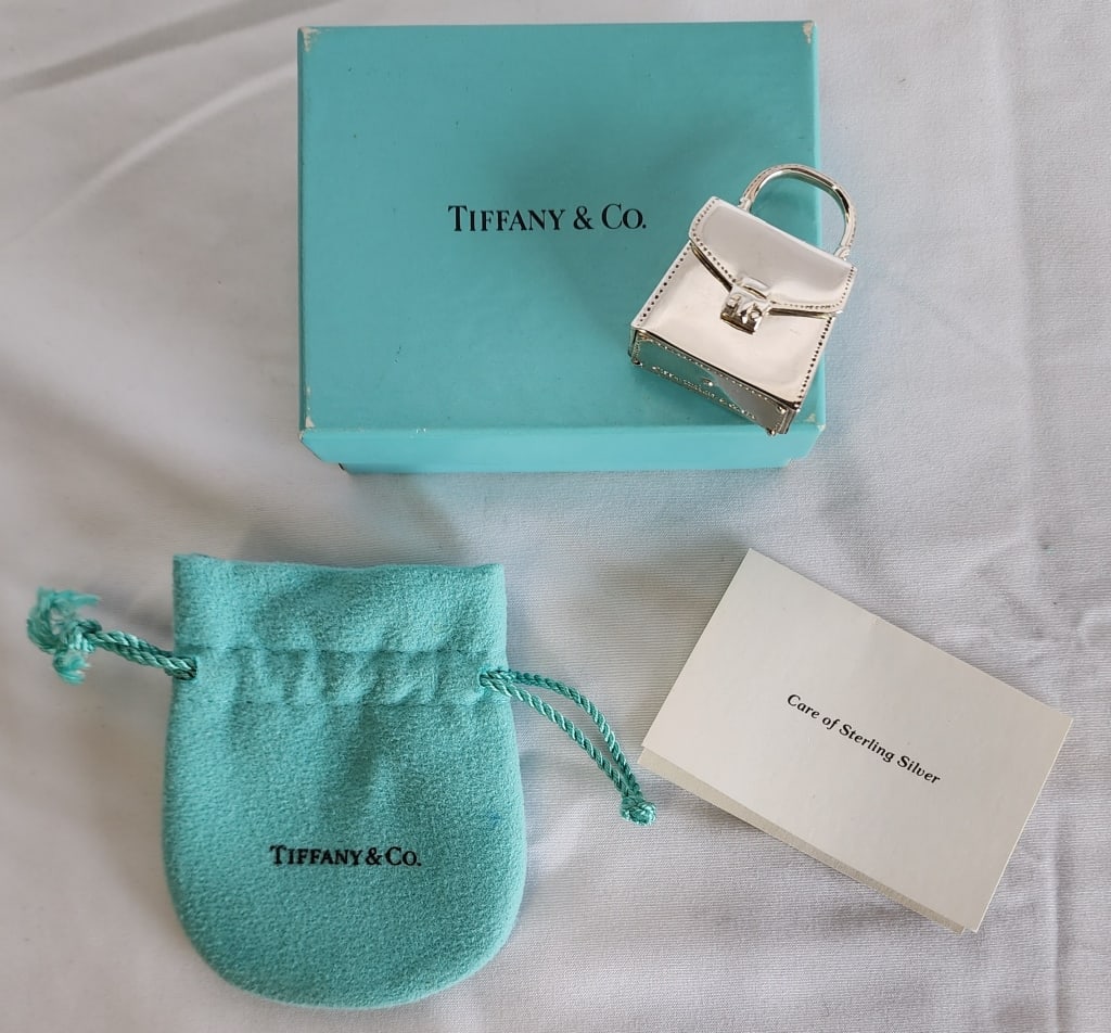 Tiffany & Co Sterling Handbag Pill Box - 1.8oz: Tiffany & Co sterling handbag pill box. Approx. 1.8oz. Marked 925 Tiffany & Co. 1994. Comes with Tiffany & Co. pouch and original box. Approx. 1.75"H x 1.25"W. Photos are considered part of the descri