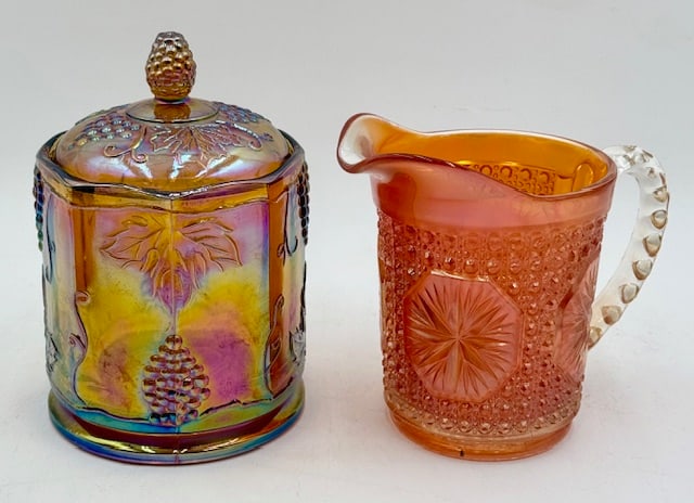 Vintage Carnival Glass Creamer and Covered Jar: 2 Pieces of vintage carnival glass. Includes marigold creamer, 5.5"h, and covered jar, 7". No markings on either. Photos are considered part of the condition and description. 109