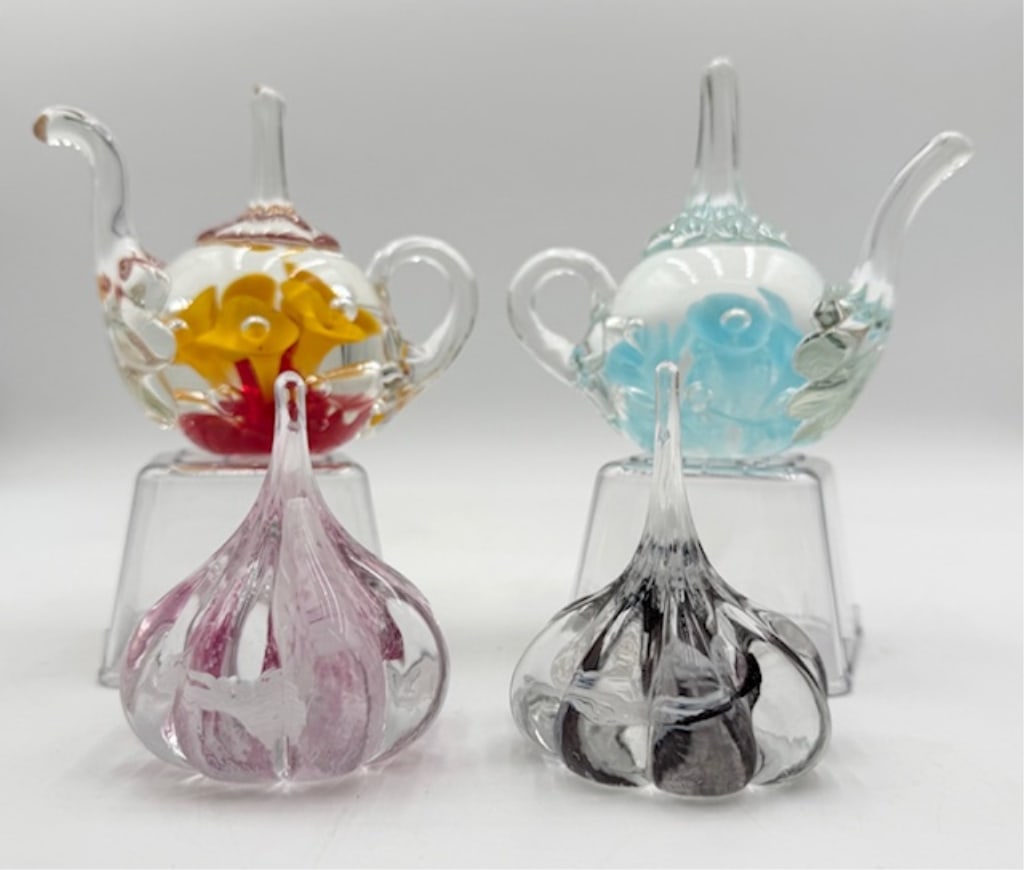 4 Signed Art Glass Ring Holders: 4 Signed art glass ring holders. Includes 2 Joe St Clair blown glass teapot ring holders. Floral design. One blue and one red/yellow. Approx. 4"H x 5"W. 2 Caithness Scotland art glass garlic bulb ring