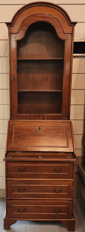 Petite Mahogany Arch Top Secretary: Petite mahogany arch top secretary. 2 Pieces. Top display features wire mesh front. Bottom includes 3 drawers. Two square drop down supports missing. Scratches present. In good used condition. Approxi