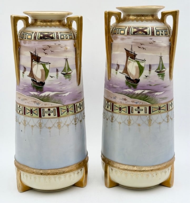 Pair Hand Painted Nippon Handled Urns: Pair of hand painted Nippon handled urns. Featuring sail boat motif and raised gold accents. One handle has been repaired. Slight variation in heights. Approximately 14.5"h x 6.5"w. Photos are conside