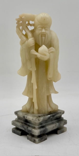 Small Shou Xing Soapstone? Sculpture: Small carved soapstone? Shou Xing sculpture. On attached base. Some scratches present. Approximately 7.25"h x 2.5"w x 2.25"d. Photos are considered part of the condition and description. 915