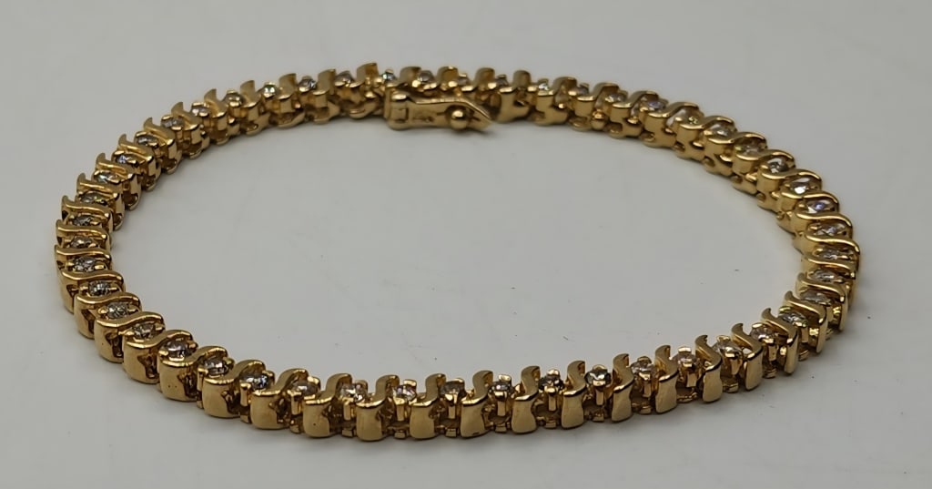 14k Diamond Tennis Bracelet - 14.64g TW: 14k Diamond tennis bracelet. 49 Diamonds set in 14k yellow gold. Clasp with latch. Approx. 7.25"L. 14.64g TW. Photos are considered part of the description and condition. R