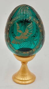 Beautiful Faberge Style Russian Green Glass Egg: Beautiful Faberge style Russian green glass egg. One side featuring gold dove and the other side a gold cross. On separate wooden stand. Egg marked Handi-work St. Petersburg Russia. 4"h. Photos are