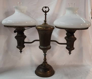 Antique Double Arm Brass Oil Lamp: Antique double arm brass oil lamp. Includes clear chimneys and white milk glass shades. Approximately 23"h x 28"w. Photos are considered part of the condition and description. 917-6