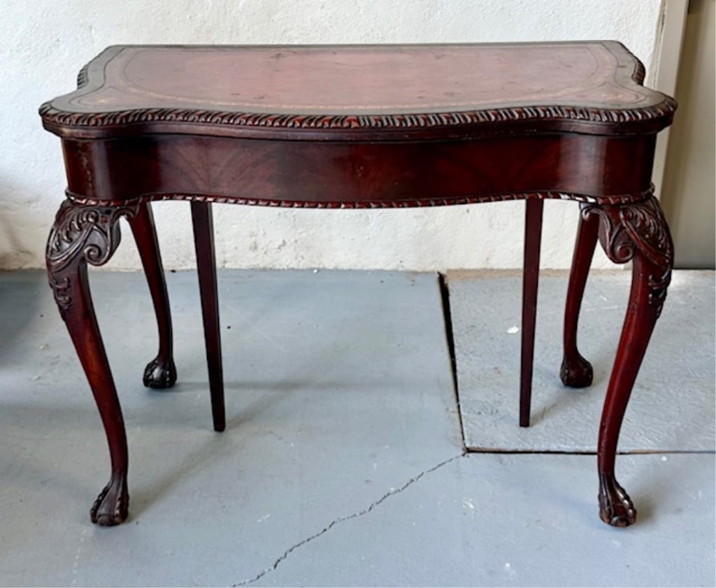 Carved Mahogany Leather Top Flip Top Console Table: Carved mahogany Queen Anne style flip top console table. Features leather top and chippendale style legs. Leather top has heavy wear and multiple imperfections. Some nicks present in wood. Approximate