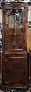 English Burled Mahogany Corner Display Cabinet: English burled mahogany corner display cabinet. Featuring upper glass door with two glass shelves and lower wood door with single wood shelf. Minor scratches present. Approximately 70.5"h x 25"w. Phot
