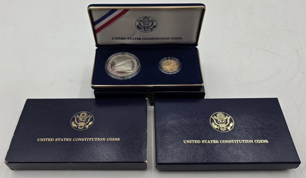 Silver & Gold 1987 Constitution Coins: Two 1987 constitution coins in display case with box. Includes 1987-w $5 gold constitution coin, 0.2418 AGW, and 1987 $1 silver constitution coin, 0.7734 ASW. Box with sleeve approximately 6" x 3.5". 