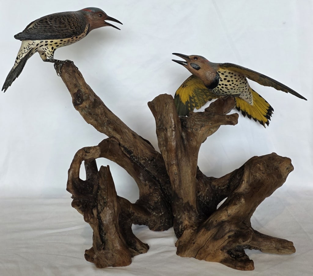 D.A. Drake Hand Crafted Northern Flicker Sculpture: D.A. Drake hand crafted nature sculpture. Featuring hand carved and hand painted flicker birds sitting on driftwood. Artist signed. Chip present in wood at base of tail feather. Approximately 19"h x 2