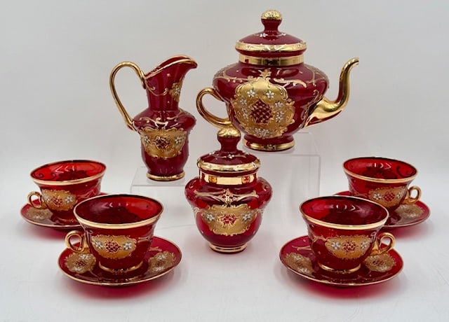 Beautiful Venetian Murano Ruby Red Tea Set: Beautiful Venetian Murano ruby red tea set. Hand painted 24k gold gilding and raised floral accents. Tea set includes 7"h x 7.5"w tea pot, 6" creamer, 6.25" covered sugar dish, 4 2.75" tea cups, and 4